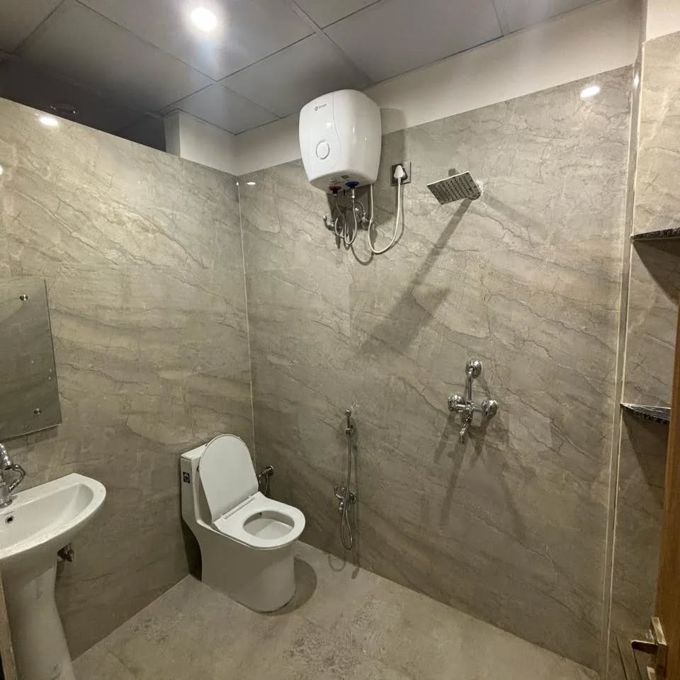 A modern attached bathroom finished in marble with hot water