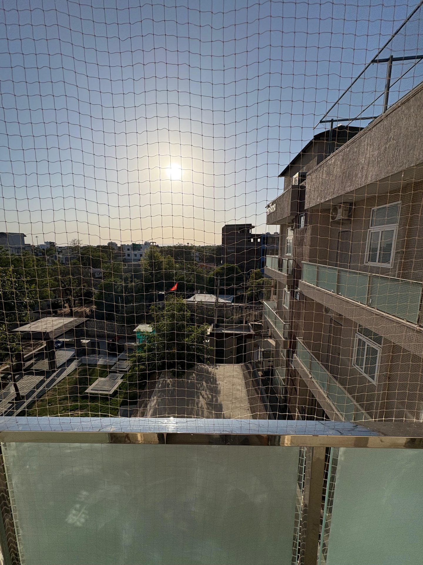 A room balcony looking toward the university at golden hour
