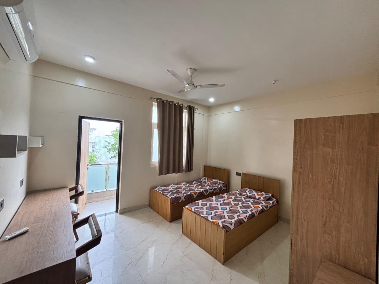 A furnished twin-sharing room with balcony